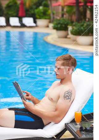 Man resting with digital tablet Man resting with digital tablet 42462254