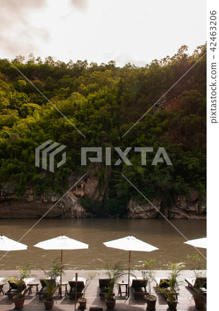 Resort style beach daybeds umbrellas by river Kwai 42463206