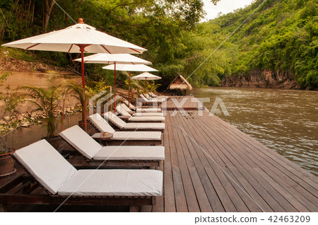 Resort style beach daybeds umbrellas by river Kwai 42463209