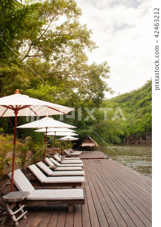 Resort style beach daybeds umbrellas by river Kwai 42463212