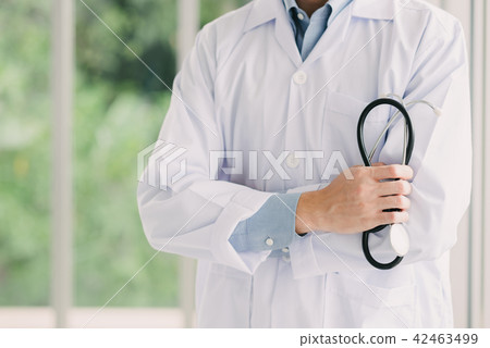Doctor with arms crossed holding stethoscope Doctor with arms crossed holding stethoscope 42463499
