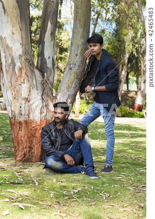 Two young men in casual trendy clothes in a park Two young men in casual trendy clothes in a park 42465483