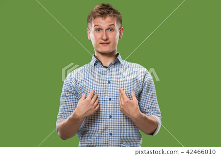 Suspiciont. Doubtful pensive man with thoughtful expression making choice against green background Suspiciont. Doubtful pensive man with thoughtful expression making choice against green background 42466010