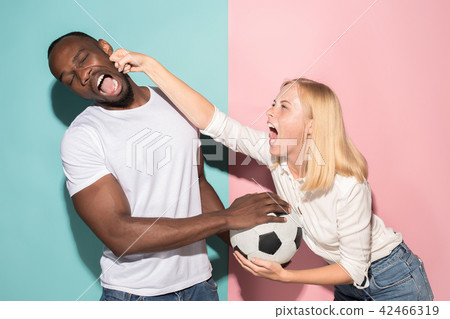 The unhappy and angry fans on colored blue and pink background. The unhappy and angry fans on colored blue and pink background. 42466319