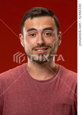 The happy business man standing and smiling against red background. 42466380
