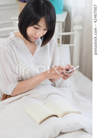 在床上滑手機的少女 42467007