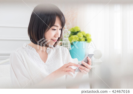 在床上滑手機的少女 42467016