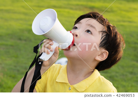 Talking into a loudspeaker while a child is playing a game 42469053