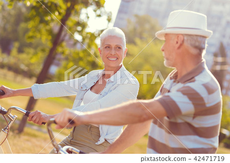 Joyful couple with bicycles gossiping outdoors 42471719