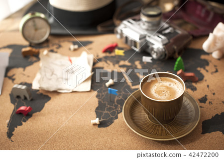 A cup of fragrant coffee on the map, an old camera and a route plan, a vintage photo. Travel and 42472200