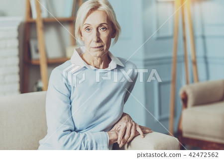 Concentrated senior woman holding hands together Concentrated senior woman holding hands together 42472562