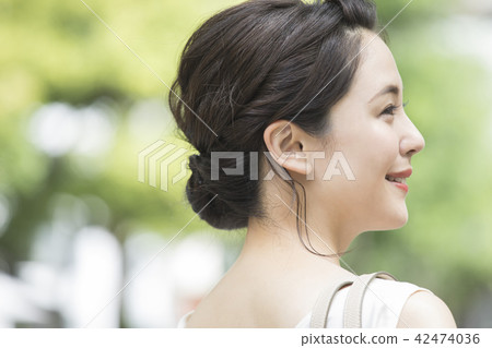 A woman to check with a mirror outdoors 42474036