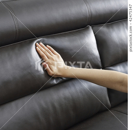 A hand touching a soft sofa A hand touching a soft sofa 42475347
