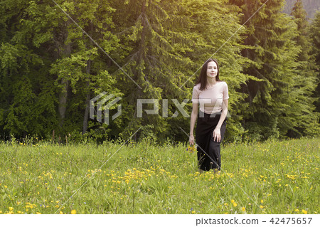 Young woman with a bouquet of flowers walking Young woman with a bouquet of flowers walking 42475657