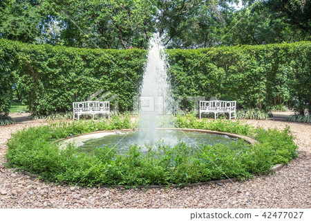 The fountain in the green garden is so hilarious. 42477027