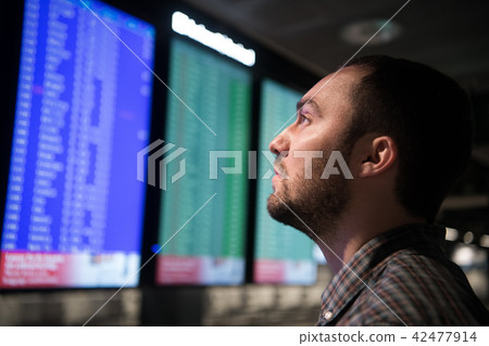 Young man in airport near flight timetable 42477914