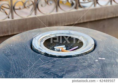 Cigarette butts in ashtray on city street 42489507