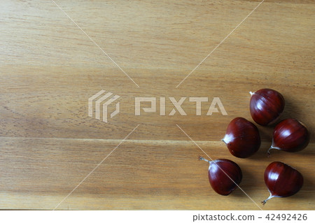 sweet chestnut fruits on a wooden board 42492426
