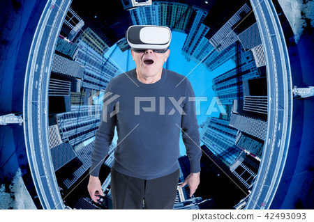 An old man in VR headset against a city buildings background. An old man in VR headset against a city buildings background. 42493093