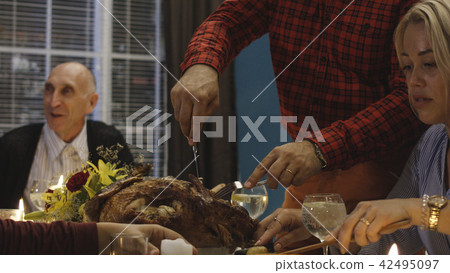 Man carving turkey on Thanksgiving dinner Man carving turkey on Thanksgiving dinner 42495097