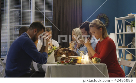 Group of friends praying on Thanksgiving day celebration Group of friends praying on Thanksgiving day celebration 42495099