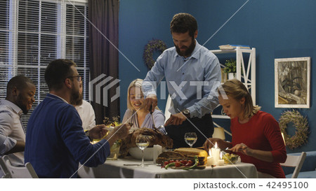 Man carving turkey on holiday dinner Man carving turkey on holiday dinner 42495100