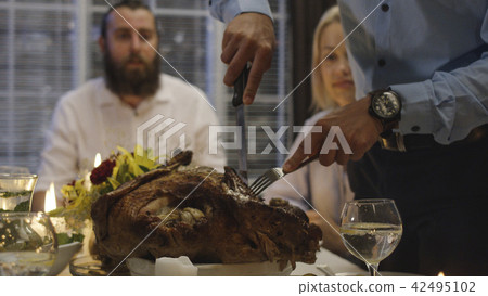 Man carving turkey on holiday dinner Man carving turkey on holiday dinner 42495102