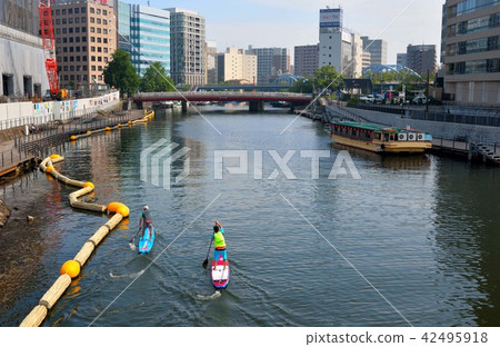 People who stand up paddle and surf at Yokohama Ooka River estuary People who stand up paddle and surf at Yokohama Ooka River estuary 42495918