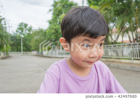 Asian boy with funny face on street. Asian boy with funny face on street. 42497680