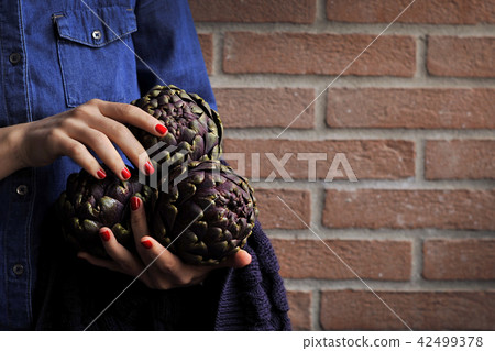 Artichokes are fresh in the hands of women. Bouquet from vegetables. Healthy Italian food. 42499378