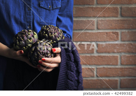 Artichokes are fresh in the hands of women. Bouquet from vegetables. Healthy Italian food. Artichokes are fresh in the hands of women. Bouquet from vegetables. Healthy Italian food. 42499382