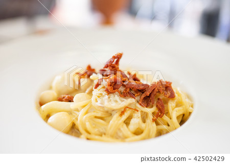 spagehtti cabonara on plate with bacon close up 42502429