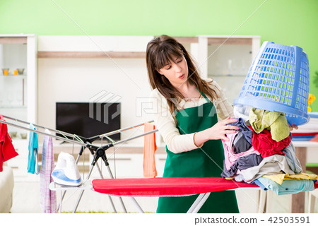 Young woman ironing clothing at home Young woman ironing clothing at home 42503591