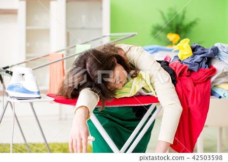 Young woman ironing clothing at home 42503598