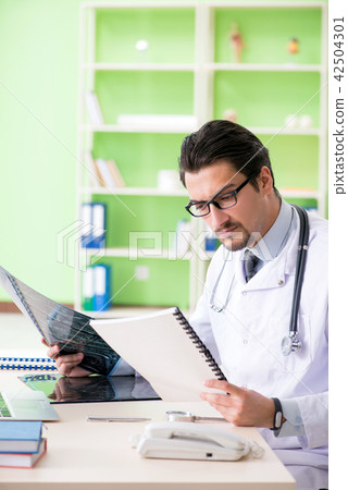 Doctor radiologist looking at x-ray scan in hospital Doctor radiologist looking at x-ray scan in hospital 42504301