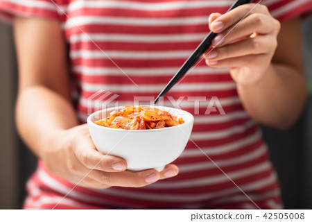 Woman holding chopsticks for eating kimchi cabbage Woman holding chopsticks for eating kimchi cabbage 42505008