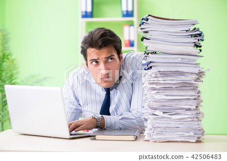 Businessman having problems with paperwork and workload 42506483