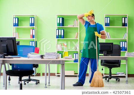 Young male handsome professional cleaner cleaning floor with bro Young male handsome professional cleaner cleaning floor with bro 42507361