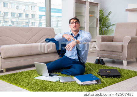 Businessman taking work home and working overtime 42507483