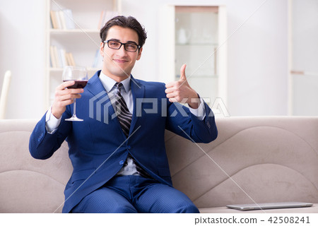Businessman drinking wine sitting at home 42508241