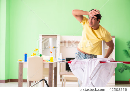 Leg injured man doing clothing ironing at home 42508256