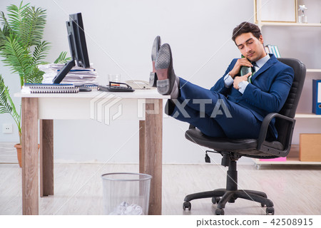 Young businessman employee drinking in the office at desk Young businessman employee drinking in the office at desk 42508915