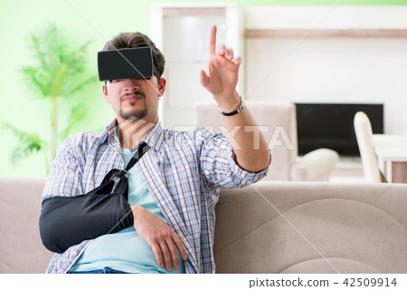 Young student man with hand injury wearing virtal glasses Young student man with hand injury wearing virtal glasses 42509914