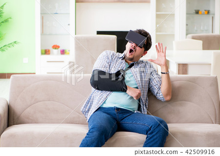 Young student man with hand injury wearing virtal glasses Young student man with hand injury wearing virtal glasses 42509916
