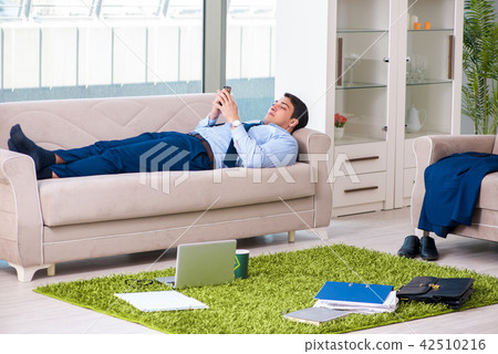 Businessman taking work home and working overtime Businessman taking work home and working overtime 42510216