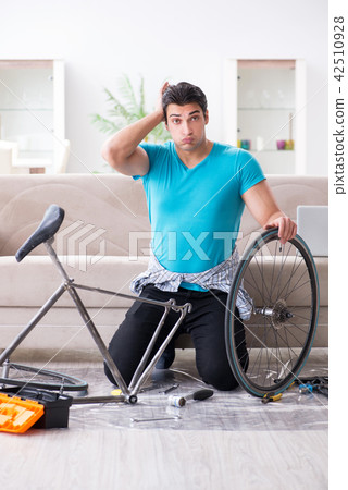 Young man repairing bicycle at home Young man repairing bicycle at home 42510928
