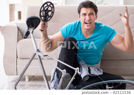 Young man repairing bicycle at home Young man repairing bicycle at home 42511536