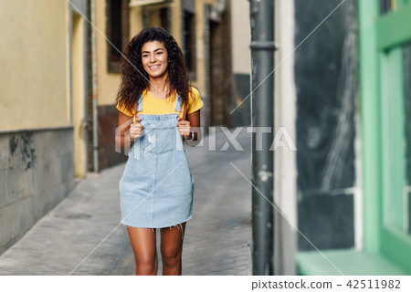 Young North African woman with black curly hairstyle outdoors. Young North African woman with black curly hairstyle outdoors. 42511982