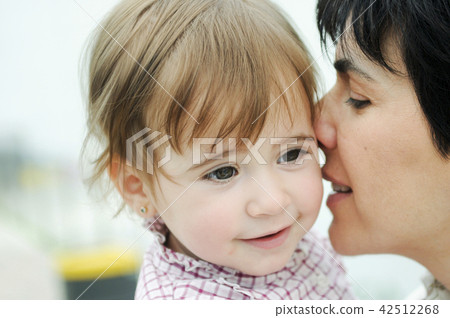 Woman and her cute little daughter are hugging Woman and her cute little daughter are hugging 42512268