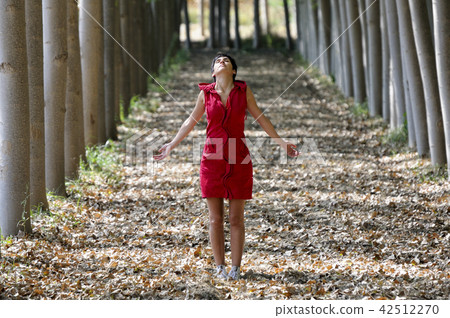 Woman dressed in red, meditating in the forest Woman dressed in red, meditating in the forest 42512270